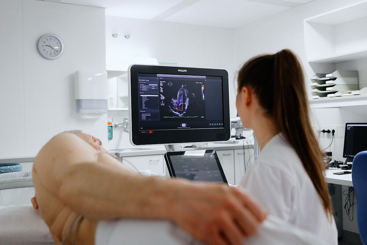 Mitarbeiterin führt eine Ultraschalluntersuchung bei einem Patienten durch