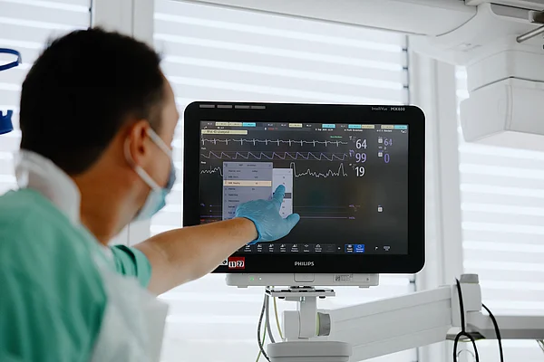 Pflegekraft überwacht die Vitalwerte am Monitor