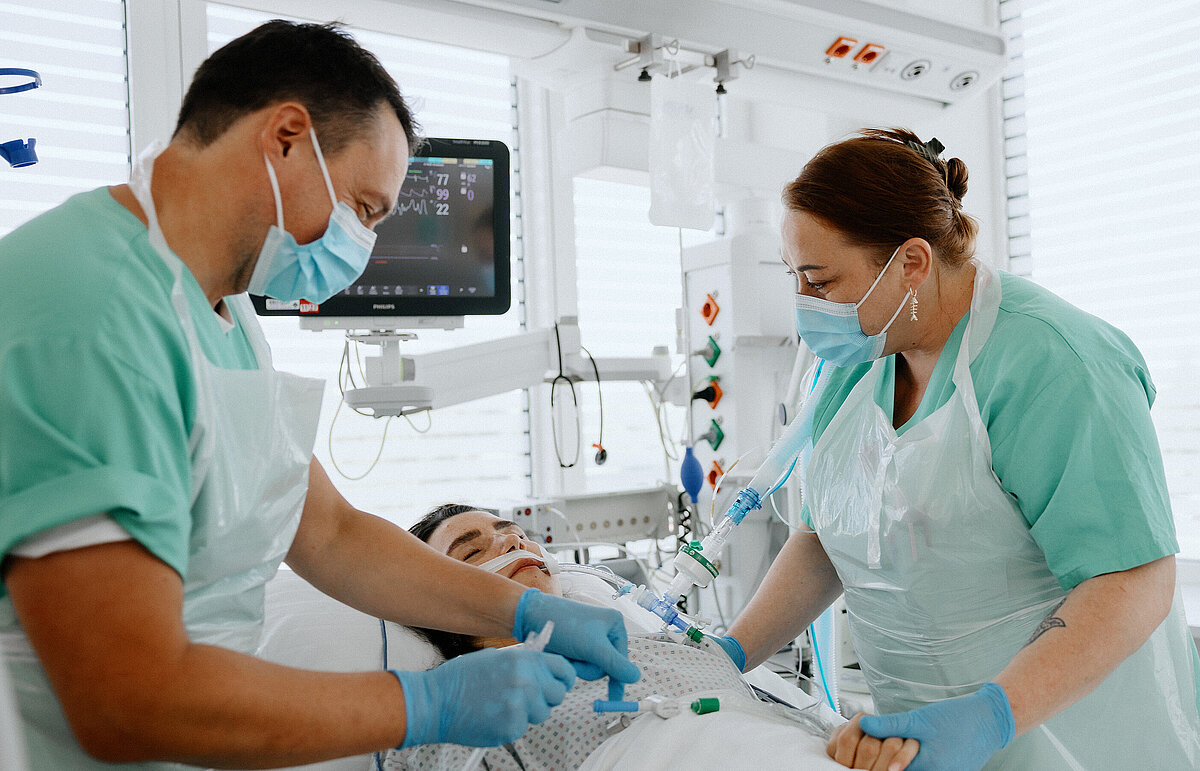 Zwei Pflegekräfte prüfen sorgfältig alle Schläuche der Patientin.