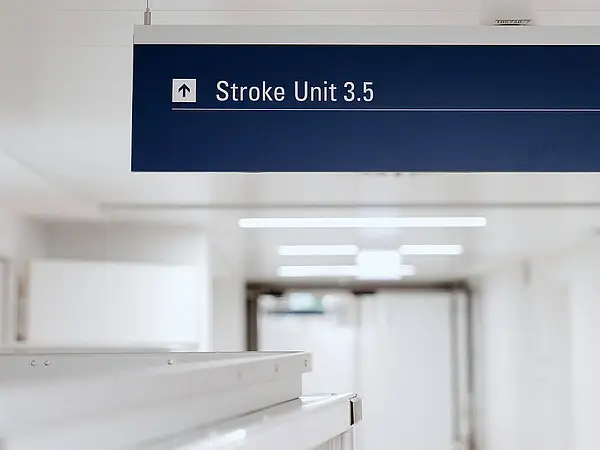 Blick auf ein Schild mit der Aufschrift „Stroke Unit 3.5“ in einem Krankenhausflur.
