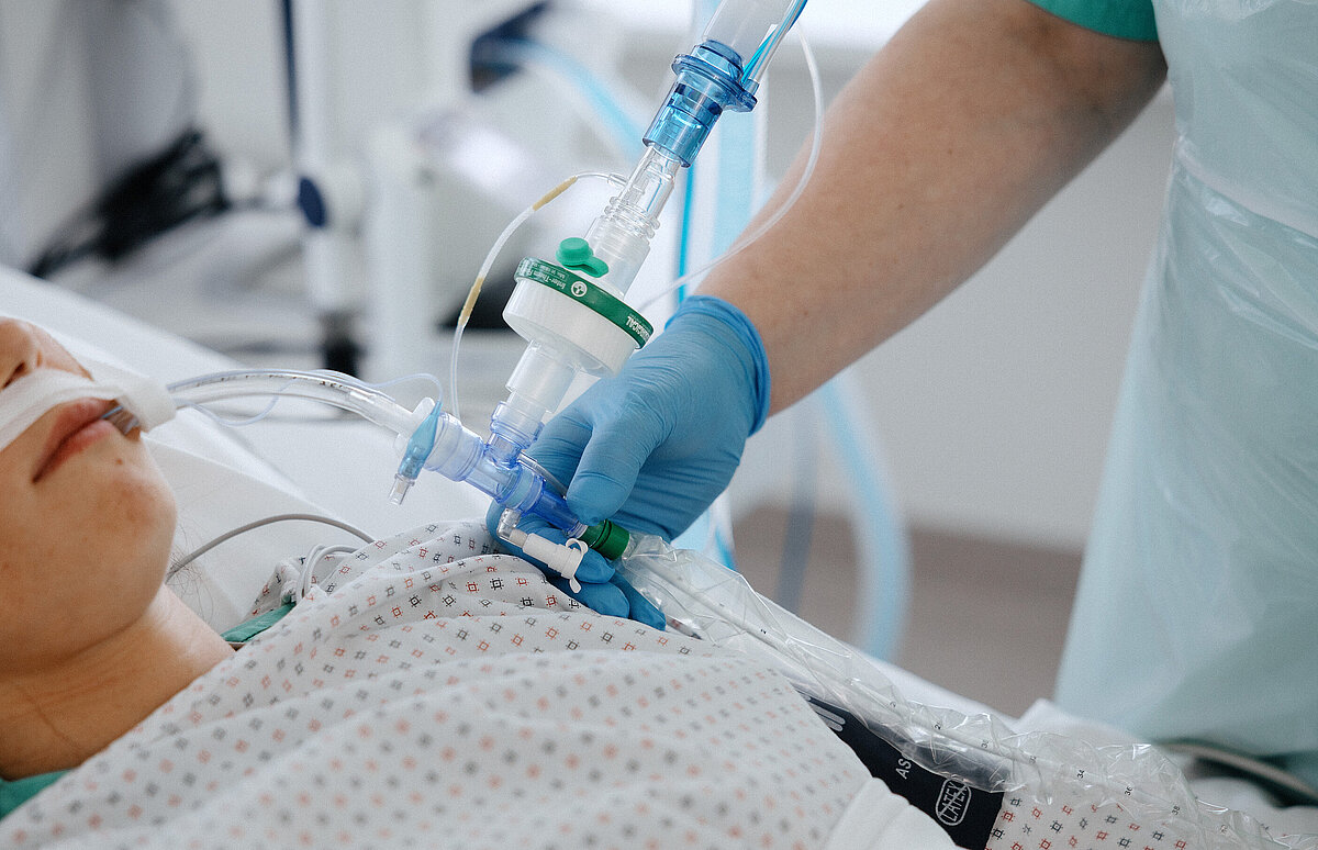 Pflegekraft betreut und überwacht ihre Patientin bei invasiver Beatmung