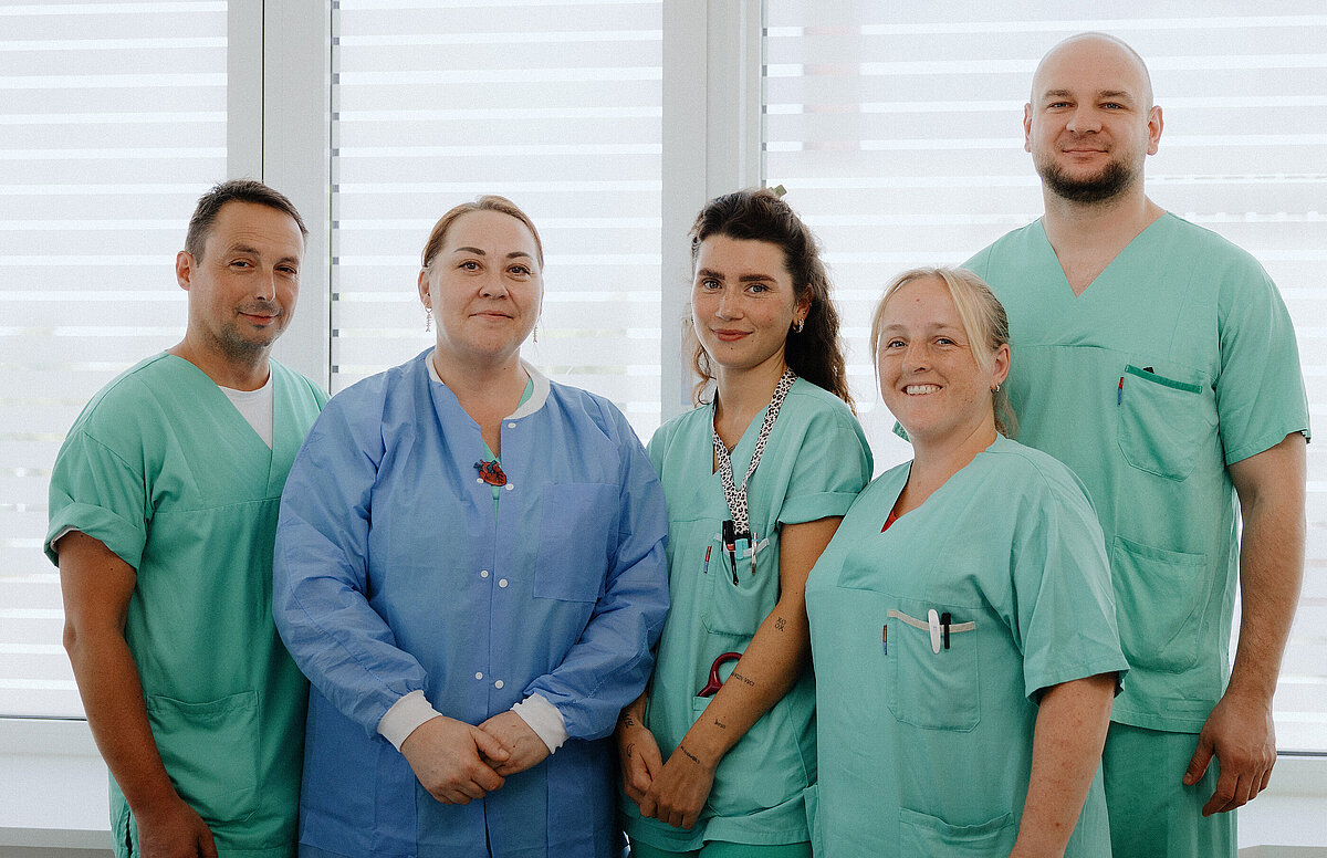 Ein Team von Pflegekräften lächeln freundlich vor der Kamera