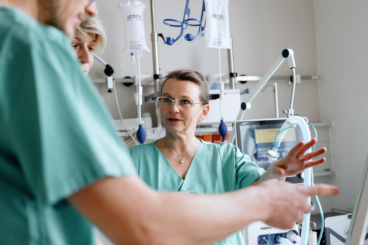 Zwei medizinische Mitarbeiterinnen im Gespräch in einem Patientenzimmer
