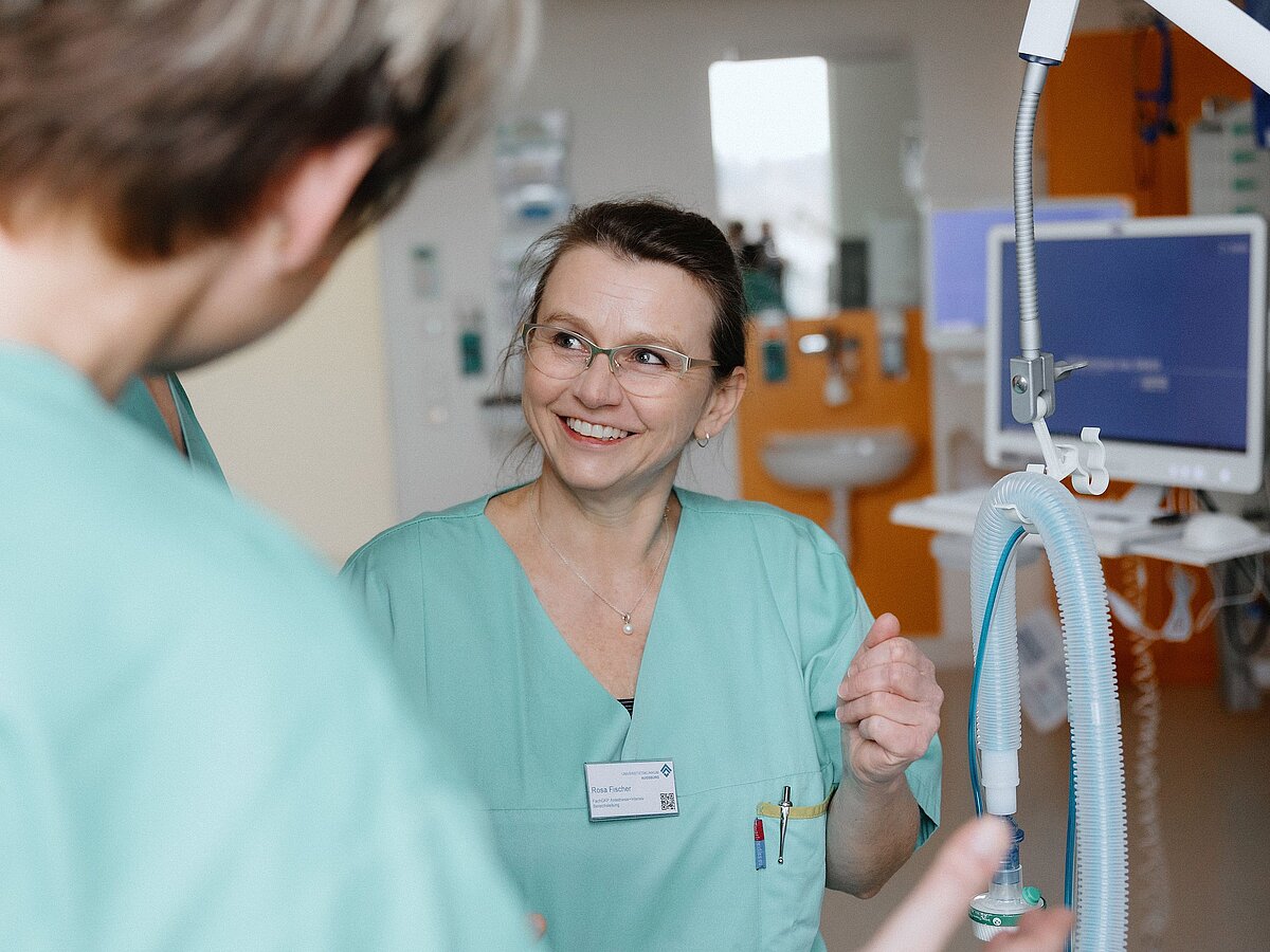 Pflegekraft im Gespräch mit Kollegen im Zentrum für Intensivtherapie