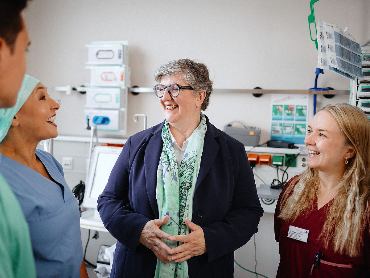Kollegiale Besprechung zwischen einer leitenden Fachkraft und medizinischen Teammitgliedern im Zentrum für Intensivtherapie des Universitätsklinikums Augsburg.